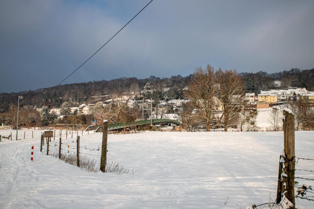 Blick auf Weingartsgasse vom Kreuz an der Siegalle aus. Schnee bedeckt die Felder und auch Weingartsgasse selber. Es ist tiefster, weißer, Winter.